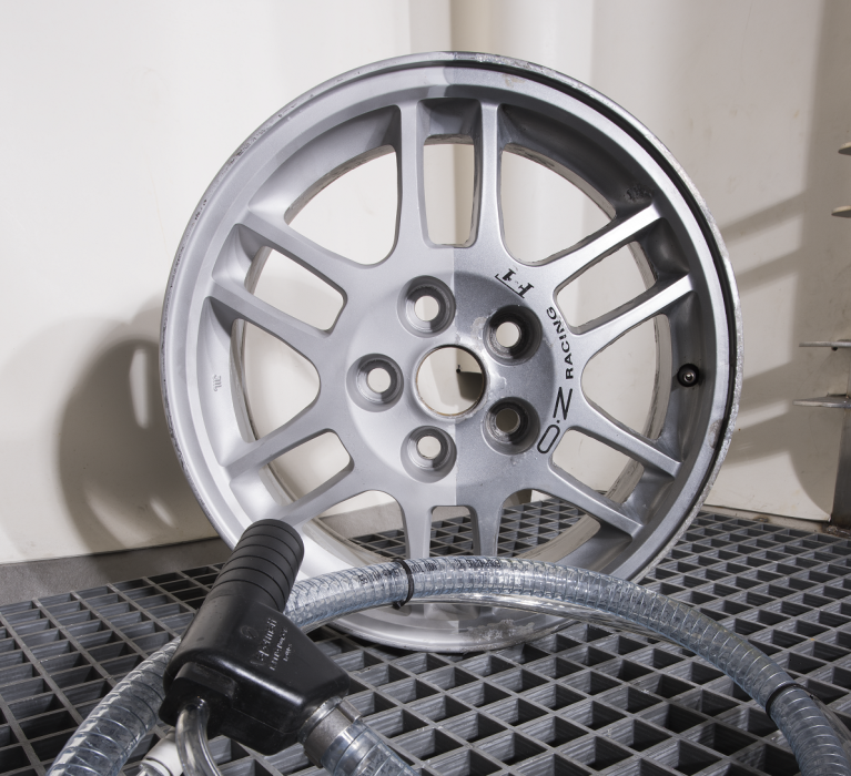 Alloy car wheel in a Vapormatt wet blasting cabinet with blast gun