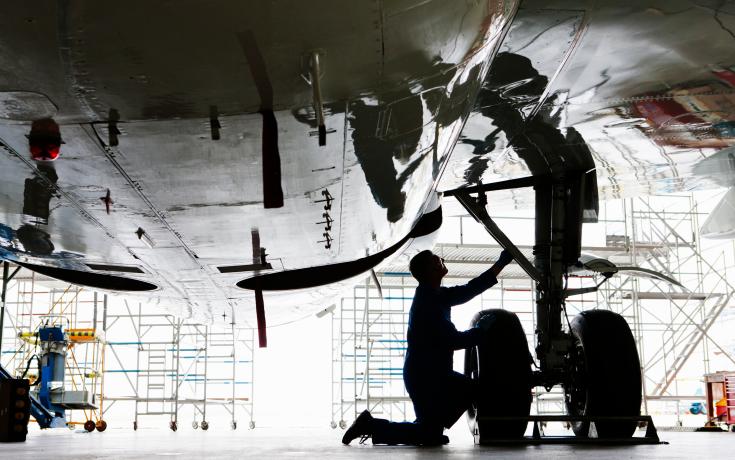 Person inspecting aircraft undercarriage