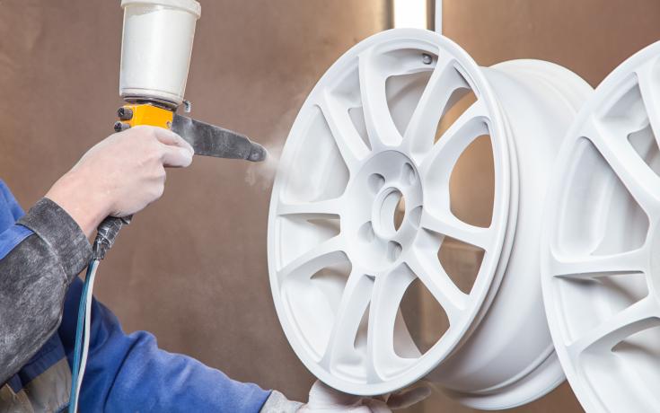 Car wheel being spray painted