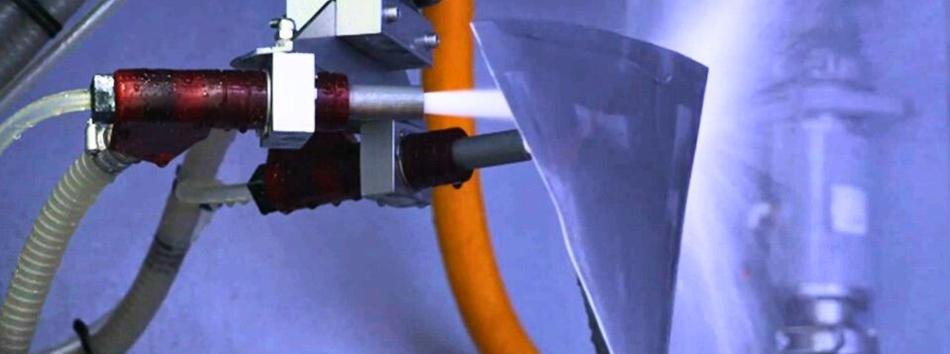 A jet engine fan blade being wet peened inside a Vapormatt Cougar+ automatic wet blasting machine