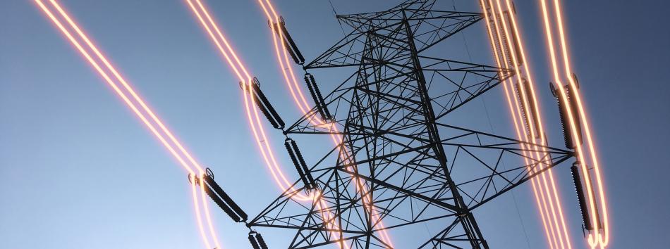 Overhead conductors shown illuminated attached to an electricity pylon