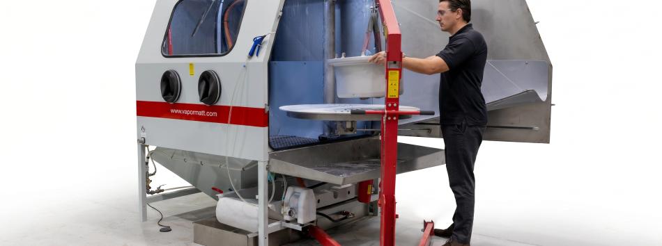 Vapormatt PumaXL manual wet blasting machine with an aircraft wheel being loaded on the turntable