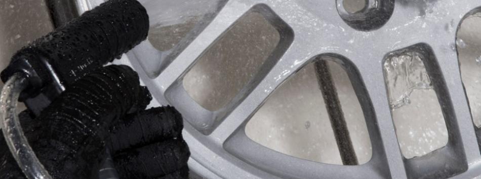 Alloy wheel being cleaned and finished by wet blasting