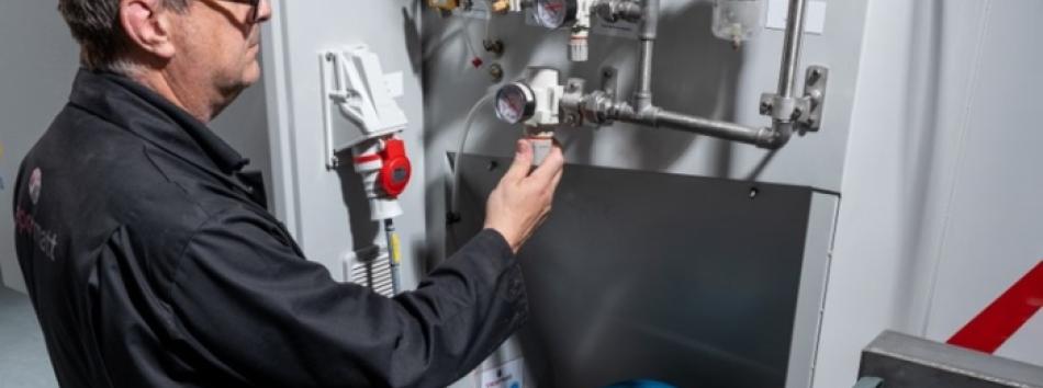 Vapormatt engineer maintaining a Vapormatt Cougar + automatic wet blasting machine