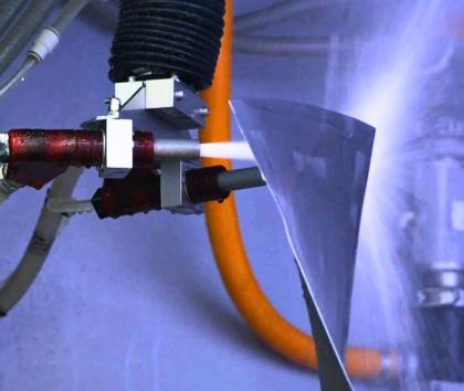A jet engine fan blade being wet peened inside a Vapormatt Cougar+ automatic wet blasting machine