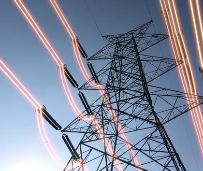 Overhead conductors shown illuminated attached to an electricity pylon