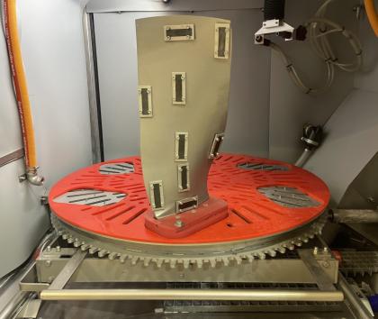 A jet engine fan blade mounted in a Cougar+ wet blasting machine with Almen strips fitted for peening measurement