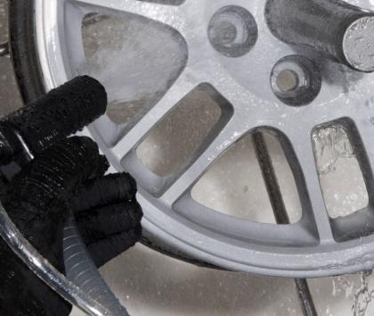 Alloy wheel being cleaned and finished by wet blasting