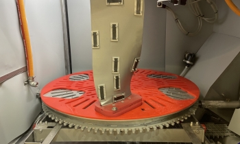 A jet engine fan blade mounted in a Cougar+ wet blasting machine with Almen strips fitted for peening measurement
