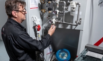 Vapormatt engineer maintaining a Vapormatt Cougar + automatic wet blasting machine