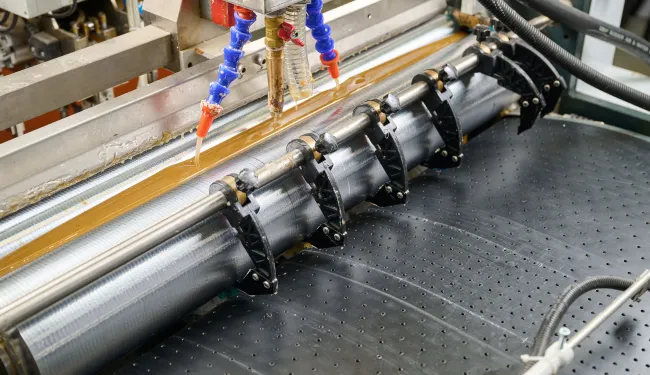 Glue being applied to a surface in an industrial process