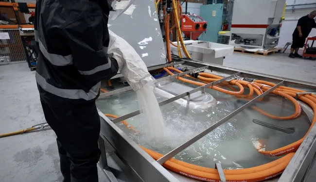 Blast media being added to a Vapormatt Leopard Sump manual wet blasting machine