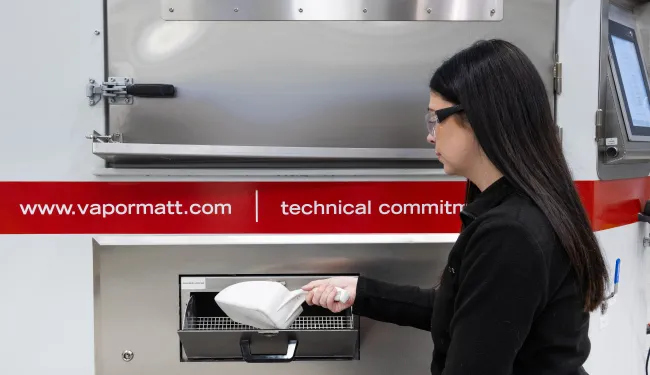 A Vapormatt automatic wet blasting machine being loaded with blast media