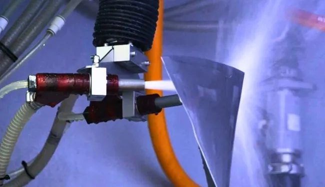 Aircraft fan blade being wet blasted