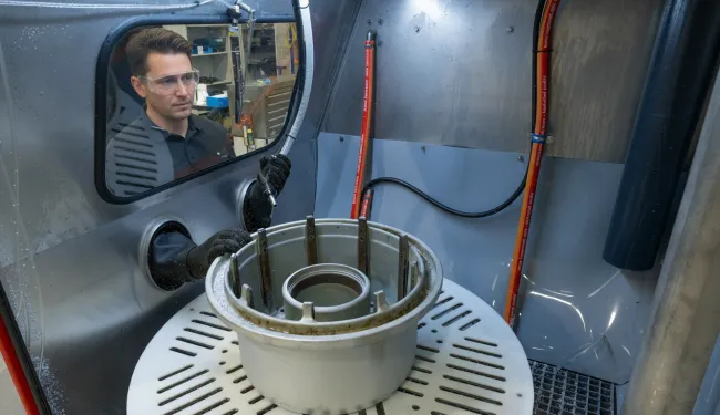 Vapormatt PumaXL manual wet blasting machine with an aircraft wheel loaded on the turntable