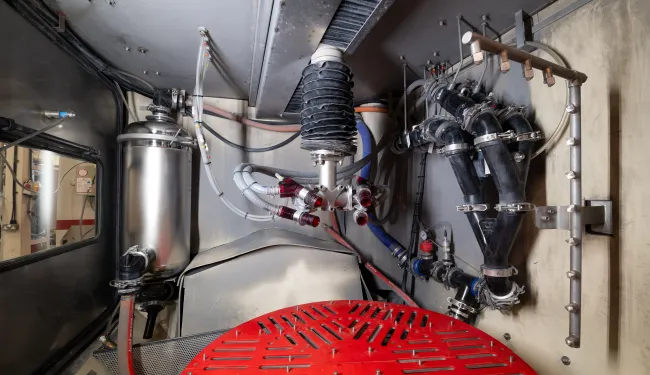 The inside of Vapormatt Sabre automatic wet blasting machine configured for finishing aerospace jet engine components