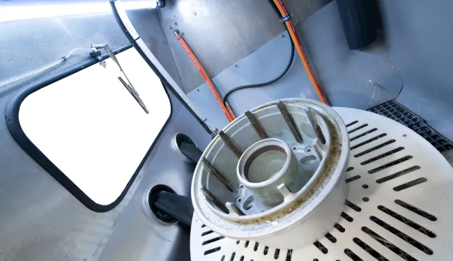 Vapormatt PumaXL manual wet blasting machine with aircraft wheel loaded on the turntable