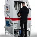 Vapormatt Puma manual wet blasting machine - left hand quarter view with operator