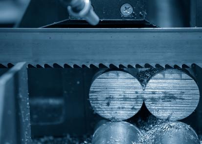 Bandsaw blade cutting through metal rods