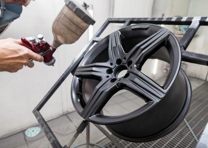 Car wheel being spray painted